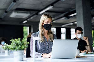 employees working on their computers with masks during the global pandemic