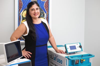 Barbara Alfaro Stands in front of laser equipment