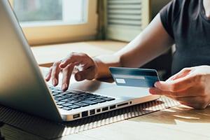 woman using credit card on computer