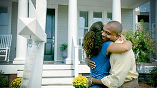 man and woman hugging on front porch