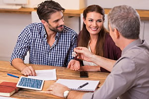 smiling couple meeting with realtor