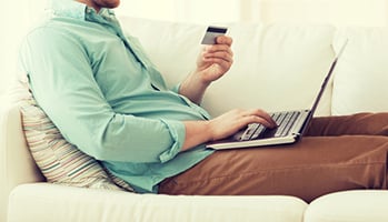 man using credit card on laptop