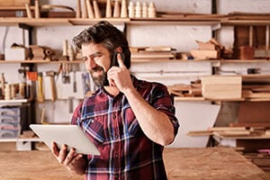 contruction businessman on phone holding tablet
