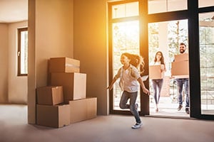 family entering new home with moving boxes