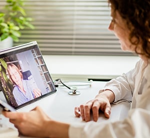 smiling doctor video conferencing patient
