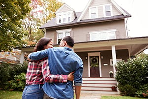 smiling couple walking toward new house