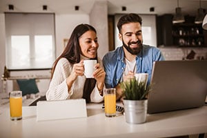 smiling couple reviewing mortgage rates on laptop