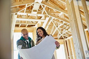 couple reviewing building plans in a home under construction