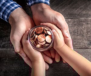 dad and child holding a jar of pennies