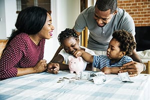 family counting pennies into piggy bank