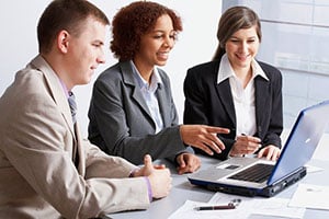 3 employees working together on laptop