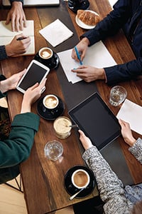 birds eye of business people on their smart devices drinking coffee