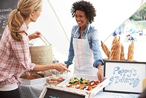 smiling baker and customer at farmers market