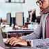 A person wearing a headset and using a Lenovo computer