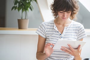 Young woman budgeting on tablet