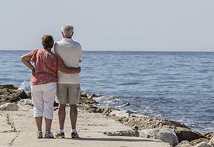 retired couple at the beach looking at the water