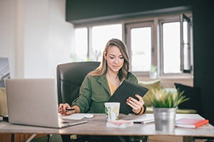 woman at desk on tablet