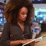 A person reading a book in a bookstore