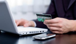 person using online banking holding credit card