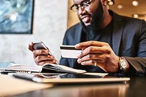 man using credit card and cell phone