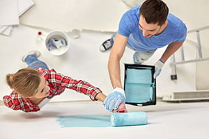 man and woman painting wall blue