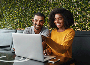 smiling couple enrolling in online banking