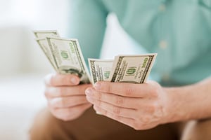 hands holding cash representing small business cash management