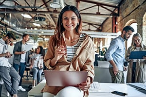 casual work office with woman smiling on laptop