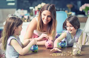 Mother with two children holding piggy banks