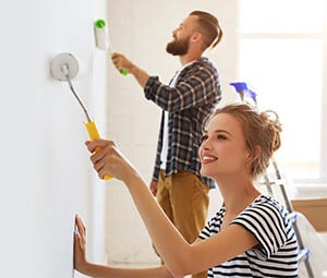 Man and woman painting walls in their home
