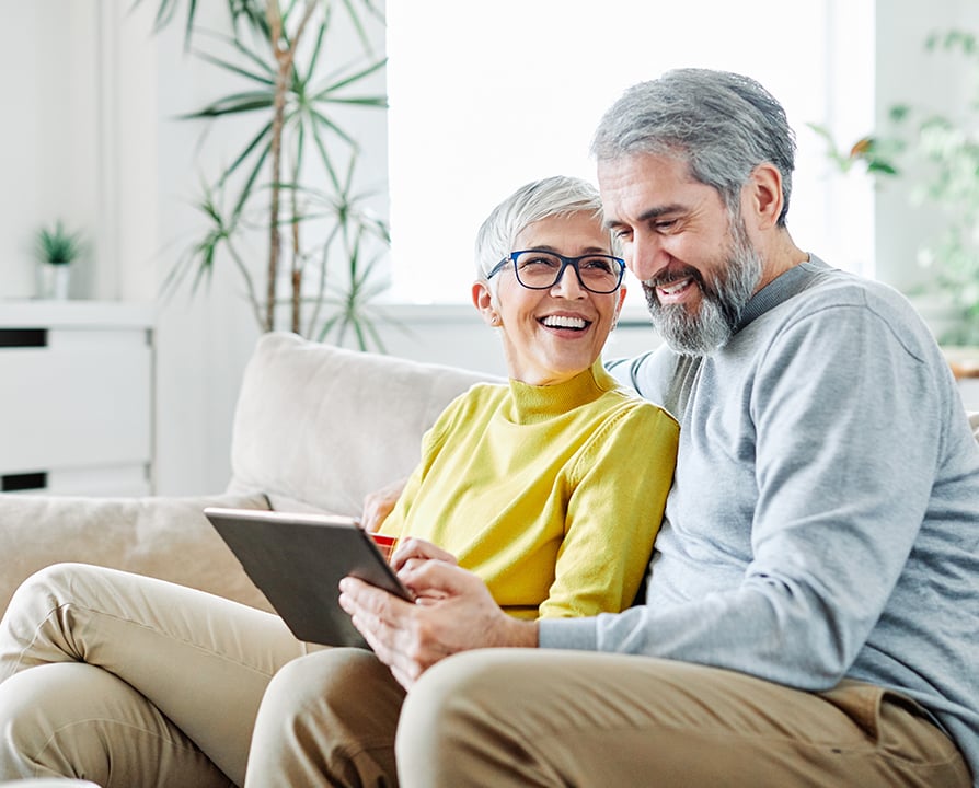 894x720-smiling-couple-looking-at-tablet