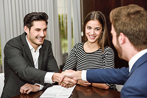 young couple happily working on paperwork with small business banker